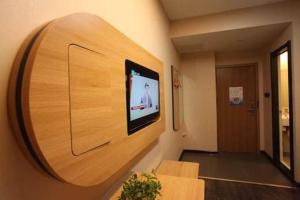 a room with a flat screen tv on a wall at Thank Inn Plus Hotel Shandong Rizhao Donggang District Lighthouse Plaza in Rizhao