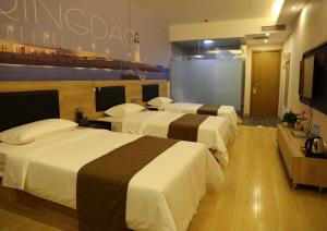 um quarto de hotel com três camas e uma televisão de ecrã plano em Thank Inn Plus Hotel Shandong Qingdao Jimo Development Zone New Government em Qingdao