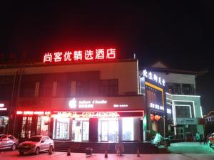a building with neon signs in a city at night at Thank Inn Plus Hotel Shandong Jining Qufu City Sankong Tourist Center in Jining