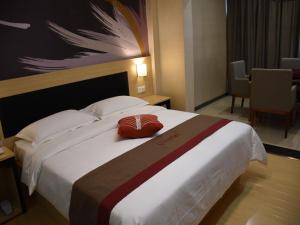 Habitación de hotel con cama grande y almohada roja. en Thank Inn Plus Hotel Chongqing Wanzhou District Pedestrian Street, en Wanxian