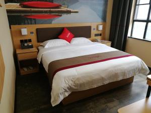 een hotelkamer met een groot bed met rode kussens bij Thank Inn Plus Hotel Guangdong Zhaoqing Gaoyao City Yaonan 2nd Road in Zhaoqing