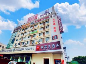 un edificio con muchas señales a su lado en Thank Inn Plus Hotel Jiangsu Suzhou Dushu Lake Dongxing Road, en Suzhou