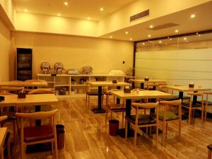 un restaurante con mesas y sillas en una habitación en Thank Inn Plus Hotel Shandong Jinan Jiyang HuaYang Road, en Jiyang