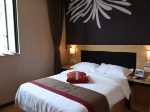 Un dormitorio con una cama grande con una almohada roja. en Thank Inn Plus Hotel Chongqing Wanzhou District Pedestrian Street, en Wanxian