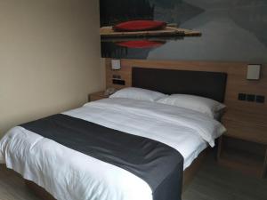 una camera da letto con un grande letto bianco con un cuscino rosso di Thank Inn Plus Hotel Anhui Chizhou Jiuhuashan Scenic Area Yonghua Road a Chizhou