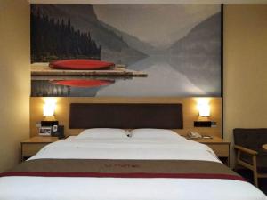 een slaapkamer met een groot bed en een schilderij aan de muur bij Thank Inn Plus Hotel Jiangxi Fuzhou Jinxi County Government Square in Fuzhou