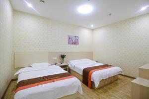 a hospital room with two beds in it at Thank Inn Plus Hotel Shandong Jining High-tech District Huangtun Plaza Commercial Building in Jining