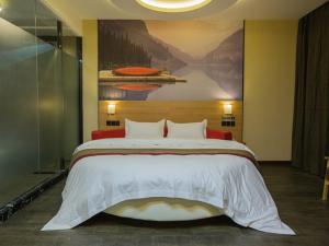 a bedroom with a large bed with a painting on the wall at Thank Inn Plus Hotel Hebei Handan Congtai District Lianfang West Road in Handan