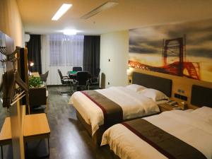 Cette chambre d'hôtel comprend deux lits, une table et des chaises. dans l'établissement Thank Inn Plus Hotel Guangxi Hezhou Zhaoping County Huangyao Town, à Gongqiao