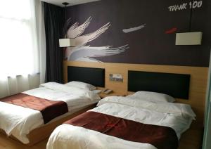 a hotel room with two beds and a sign on the wall at Thank Inn Plus Hotel Shandong Zaozhuang Tengzhou Parallel Road Qinghe Shangcheng Community in Zaozhuang