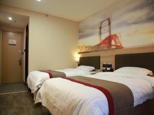 a hotel room with two beds and a painting on the wall at Thank Inn Plus Hotel Shandong Jining Qufu City Sankong Tourist Center in Jining