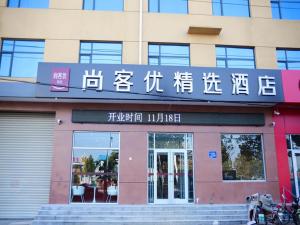 una tienda frente a un edificio con escritura en Thank Inn Plus Hotel Hebei Cangzhou Botou Development Zone Sanjing Road, en Cangzhou
