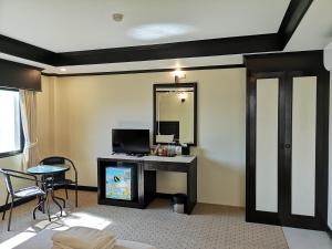 a hotel room with a desk and a mirror at Betong Hello Hotel in Betong