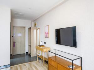 a living room with a flat screen tv on a wall at Up And In Shandong Qingdao Jiaozhou Lanzhou East Road New Bus Station in Qingdao