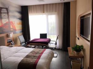 ein Hotelzimmer mit einem Bett und einem Fenster in der Unterkunft Thank Inn Plus Hotel Hebei Langfang Art Avenue Danfeng Park Exhibition in Langfang