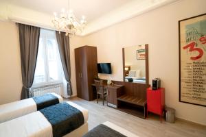 ローマにあるArchi di Roma Guest Houseのベッド、デスク、鏡が備わる客室です。