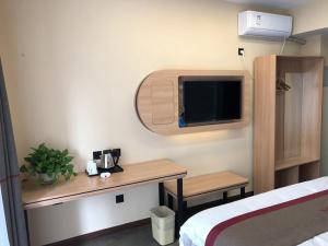 a hotel room with a desk and a tv at Thank Inn Plus Hotel Hebei Langfang Art Avenue Danfeng Park Exhibition in Langfang