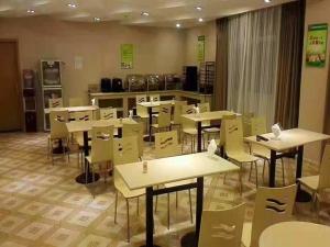 una clase con mesas y sillas en una cafetería en Thank Inn Plus Jiangxi Jingdezhen Fuliangxian Hongyuanzhen Beiqizhudi en Jingdezhen
