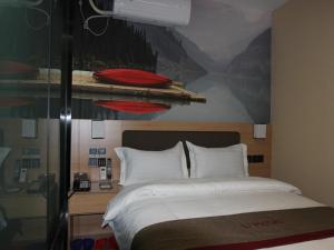 ein Schlafzimmer mit einem großen Bett und einem Gemälde an der Wand in der Unterkunft Thank Inn Plus Hotel Henan Zhengzhou Jinshui District Wenhua Road Chenzhai in Zhengzhou