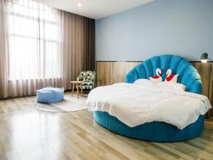 a bedroom with a large bed with a blue chair at Up And In Shandong Qingdao Jiaozhou Lanzhou East Road New Bus Station in Qingdao