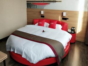a large bed with a red headboard in a room at Thank Inn Plus Hotel Shandong Binzhou Huimin County Huji Driving Test Center in Binzhou