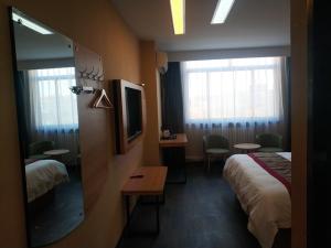 a hotel room with two beds and a mirror at Thank Inn Plus Hotel Shandong Rizhao Ju County Chengyang South RoadHospital of Chinese Traditional Medicine in Rizhao