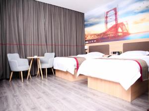 a hotel room with two beds and a table and chairs at Thank Inn Plus Hotel Hebei Cangzhou Botou Development Zone Sanjing Road in Cangzhou