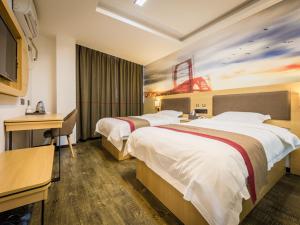 a hotel room with two beds and a television at Thank Inn Plus Hotel Jiangxi Ganzhou Nankang District East Bus station in Ganzhou