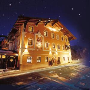 a large yellow building with lights on it at night at Hotel Reitlwirt in Brixen im Thale