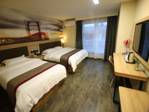 a hotel room with two beds and a desk at Thank Inn Plus Hotel Shandong Jining Qufu City Sankong Tourist Center in Jining