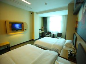 a hotel room with two beds and a flat screen tv at Thank Inn Plus Hotel Yunnan Honghe Gejiu City Renmin Road in Gejiu