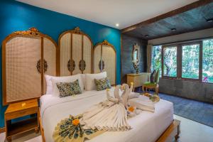 a bedroom with a large bed in a room at Menzel Ubud in Ubud