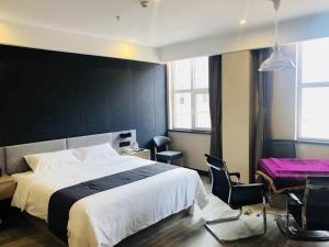 1 dormitorio con 1 cama grande, mesa y sillas en Thank Inn Plus Hotel Hebei Cangzhou Qing County Xinhua East Road en Cangzhou
