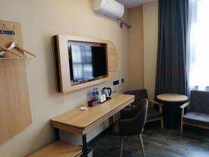een kamer met een tafel en een tv aan de muur bij Thank Inn Plus Hotel Guangdong Zhaoqing Gaoyao City Yaonan 2nd Road in Zhaoqing