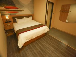 a bedroom with a large bed and a mirror at Thank Inn Plus Hotel Hebei Xingtai Guangzong County North Outer Ring Road in Xingtai