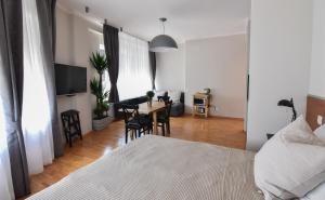 a bedroom with a bed and a dining room table at Karlo Main Square Apartments in Zagreb