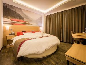 a bedroom with a large bed and a desk at Thank Inn Plus Hotel Jiangxi Ganzhou Nankang District East Bus station in Ganzhou
