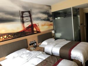 2 Betten in einem Hotelzimmer mit Wandgemälde in der Unterkunft Thank Inn Plus Hotel Hebei Langfang Art Avenue Danfeng Park Exhibition in Langfang