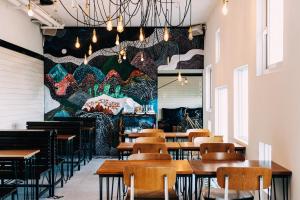 un ristorante con tavoli in legno e un grande murale di Ocean Day By Day a Manzhou