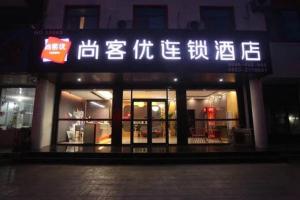 a store with a sign in front of it at night at Thank Inn Plus Hotel Shandong Rizhao Donggang District Lighthouse Plaza in Rizhao