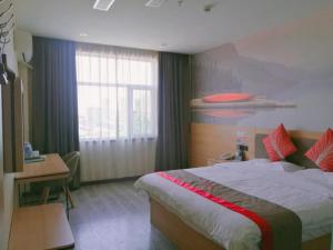 a bedroom with a bed and a desk and a window at Thank Inn Plus Hotel Hebei Baoding Lixian County Liwu Street in Baoding