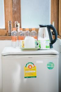 a white refrigerator with a tea kettle on top of it at Sabuy Chiangmai in Chiang Mai