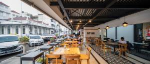 a restaurant with wooden tables and chairs on a city street at de Braga, ARTOTEL Curated in Bandung