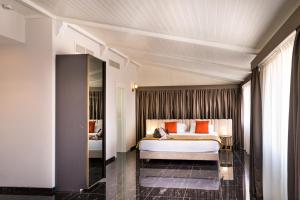 ein Hotelzimmer mit einem Bett mit orangefarbenen Kissen in der Unterkunft Villa Zaccardi in Rom