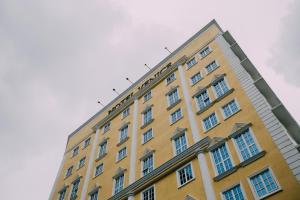 a yellow building with white windows on top of it at Hotel Venice in Kuala Lumpur