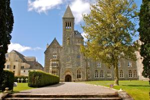 ein großes Steingebäude mit einem Turm oben in der Unterkunft Highland Club Direct in Fort Augustus