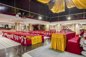 a banquet hall with red and yellow tables and chairs at New Grand Park Hotel in Surabaya