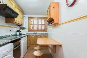 une petite cuisine avec des placards en bois et une table en bois dans l'établissement Apartamento Refugi, à Canillo