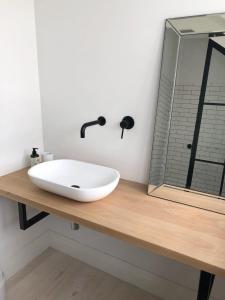 a bathroom with a white sink on a wooden counter at African Flame Apartment in Knysna +9 photos
