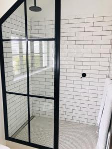 a shower with a glass door in a bathroom at African Flame Apartment in Knysna